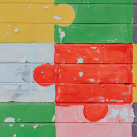 Colorful puzzle pieces painted on a brick wall